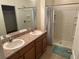 Bathroom with double sinks, shower, and linen storage at 7633 W Lenox Cir, Punta Gorda, FL 33950