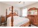 Spacious bedroom with a wooden post bed and ceiling fan at 17084 Acapulco Rd # 222, Punta Gorda, FL 33955