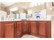Double vanity bathroom with wood cabinets and corner sink at 17084 Acapulco Rd # 222, Punta Gorda, FL 33955