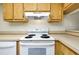 Close-up of electric range and overhead vent hood in kitchen at 1515 Forrest Nelson Blvd # G102, Port Charlotte, FL 33952