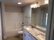 Bathroom with a double sink vanity, granite countertop, and a shower and bathtub at 14326 Edsel Dr, Port Charlotte, FL 33981
