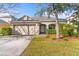 Charming single-Gathering home showcasing a well-manicured lawn and an attached two-car garage at 18457 New London Ave, Land O Lakes, FL 34638