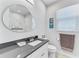 A bathroom featuring a modern oval mirror, a toilet, a towel rack, and a sink at 630 Coronado Dr, Punta Gorda, FL 33950