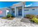 Inviting front entrance with blue door, gray pavers, and landscaped garden beds at 630 Coronado Dr, Punta Gorda, FL 33950