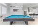 Well-lit game room featuring a pool table and bar seating that overlooks the modern kitchen at 630 Coronado Dr, Punta Gorda, FL 33950