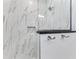 The walk in shower featuring marble-style tiling and built in shelves at 630 Coronado Dr, Punta Gorda, FL 33950