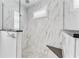 Elegant shower with marble tile, glass enclosure, and built-in seat at 630 Coronado Dr, Punta Gorda, FL 33950