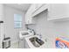 Bright laundry room with washer, dryer, and utility sink at 630 Coronado Dr, Punta Gorda, FL 33950