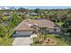 Single-story home, large yard, and canal view in the background at 2208 Barksdale St, Port Charlotte, FL 33948