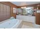 Bathroom with double vanity, soaking tub, and decorative wall art at 3228 Purple Martin Dr # 113, Punta Gorda, FL 33950