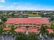 Aerial view of waterfront condo building with red tile roofs, private garages, and courtyard at 3228 Purple Martin Dr # 113, Punta Gorda, FL 33950