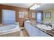 Spacious bathroom with double sinks, marble countertops, and a large soaking tub at 3228 Purple Martin Dr # 113, Punta Gorda, FL 33950