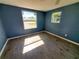 Well-lit bedroom with gray tile flooring and blue walls at 8362 Osprey Rd, Englewood, FL 34224