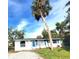 Front view of a house with palm trees and a grassy lawn at 8362 Osprey Rd, Englewood, FL 34224