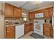 Kitchen with wood cabinets, white appliances, and tile flooring at 931 Linnaen Nw Ter, Port Charlotte, FL 33948