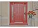 Inviting red front door with sidelights and a potted plant at 24083 Buckingham Way, Port Charlotte, FL 33980