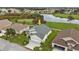 Single-story house with grey roof, two-car garage, and a view of a golf course at 24083 Buckingham Way, Port Charlotte, FL 33980