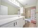 Bathroom with white vanity, tub, and floral shower curtain at 156 Morgan Se Ln, Port Charlotte, FL 33952