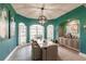 Elegant dining room with teal walls, large windows, and a statement chandelier at 1209 San Mateo Dr, Punta Gorda, FL 33950
