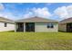 Home's exterior showcasing a large backyard and screened porch at 16024 Crofton Springs Way, Port Charlotte, FL 33953