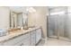 Elegant bathroom featuring a double vanity with granite countertops and a glass-enclosed shower at 25228 Rampart Blvd, Punta Gorda, FL 33983