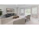 Bright living room with neutral tones, modern furniture, and sliding glass doors to the outdoor space at 25236 Rampart Blvd, Punta Gorda, FL 33983