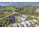 Scenic aerial view of a waterfront property featuring a private tennis court, pond, and beautiful landscaping at 4255 Oak Terrace Cir, Port Charlotte, FL 33953