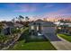 Twilight shot of single-story home with fresh landscaping and bright exterior lighting at 4255 Oak Terrace Cir, Port Charlotte, FL 33953