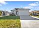 Exterior view of house on a sunny day with a large driveway and an attached two car garage at 4255 Oak Terrace Cir, Port Charlotte, FL 33953