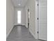 Hallway with light gray walls, white doors, white trim, and gray wood-look flooring at 4255 Oak Terrace Cir, Port Charlotte, FL 33953