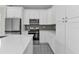 Modern kitchen with white cabinets, stainless steel appliances, and grey backsplash at 4255 Oak Terrace Cir, Port Charlotte, FL 33953