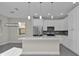 Bright modern kitchen with pendant lighting, stainless steel appliances and white cabinets at 4255 Oak Terrace Cir, Port Charlotte, FL 33953