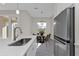 Modern kitchen featuring a stainless-steel refrigerator, quartz countertops, and stainless faucet at 4255 Oak Terrace Cir, Port Charlotte, FL 33953