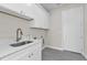 Laundry room with stainless steel sink and ample storage cabinets at 4255 Oak Terrace Cir, Port Charlotte, FL 33953