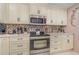 Kitchen with white cabinets, granite counters, and stainless steel appliances at 9011 Midnight Pass Rd # 329, Sarasota, FL 34242