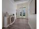 Bright and airy entryway with wood-look tile flooring and decorative console table at 14294 Mcfarland Ave, Port Charlotte, FL 33981