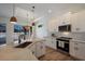 Modern kitchen with white cabinets, stainless steel appliances and breakfast bar at 14294 Mcfarland Ave, Port Charlotte, FL 33981