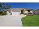Beautiful house exterior with a two-car garage and well-maintained lawn at 14294 Mcfarland Ave, Port Charlotte, FL 33981