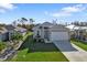 One-story house with attached garage and driveway, surrounded by grass and trees at 4255 Oak Terrace Cir, Port Charlotte, FL 33953