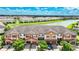 Aerial view of townhomes near a lake with lush green landscaping at 20149 Lagente Cir, Venice, FL 34293