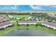 Aerial view of townhomes near a lake with lush green landscaping at 20149 Lagente Cir, Venice, FL 34293