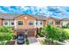 Two story townhome with orange exterior, two car garage, and landscaped front yard at 20149 Lagente Cir, Venice, FL 34293