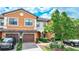 Two story townhome with orange exterior, two car garage, and landscaped front yard at 20149 Lagente Cir, Venice, FL 34293