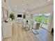 Open concept dining room features a glass dining table with white chairs and a view into the living room and kitchen at 3140 Sweet Gum Dr, Punta Gorda, FL 33982