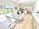 Open concept dining room with glass table and view into the kitchen at 3140 Sweet Gum Dr, Punta Gorda, FL 33982