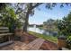 Relaxing patio view of pond with fountain, lush landscaping, and a wooden bench at 19505 Quesada Ave # Nn202, Port Charlotte, FL 33948