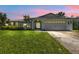 House exterior at dusk with landscaped yard and driveway at 3494 Yukon Dr, Port Charlotte, FL 33948