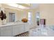 Bathroom with white cabinets, a large mirror, and glass block feature at 4077 La Costa Island Ct, Punta Gorda, FL 33950