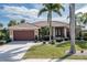 Single story home with brown garage door and landscaping at 4077 La Costa Island Ct, Punta Gorda, FL 33950