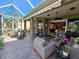 Spacious covered patio with seating area, adjacent to the kitchen and screened enclosure at 5291 Laurel Oak Ct, North Port, FL 34287